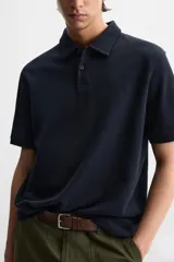 Polo verde oliva de tejido piqué, corte regular fit, cuello solapa con cierre frontal de botonadura y manga corta.