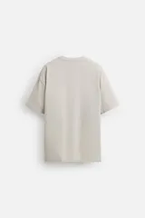 Camiseta blanca de algodón compacto, corte relaxed fit, cuello redondo y mangas cortas.
