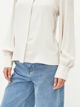 Camisa blanca de manga larga con cuello clásico y cierre frontal con botones.