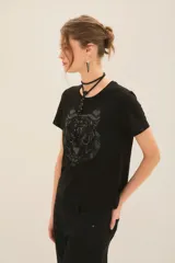 Remera de algodón color negro con cuello redondo y manga corta, caracterizada por una aplicación frontal con el diseño de un tigre.