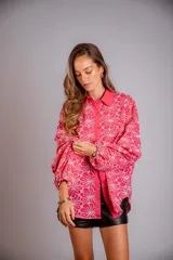 Camisa celeste con estampado de flores blancas, corte clásico, cuello camisero y mangas largas abullonadas.