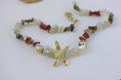 Collar de alpaca con cuentas de labradorita, jaspe rojo y cuarzo lima. Incluye una estrella de mar realizada a mano y una perla de río natural.