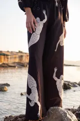 Pantalón palazzo negro con cintura elástica y estampado de sirenas blancas.