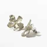 Par de caravanas plateadas con forma de flor irregular.
