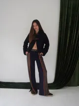 Pantalón de paño combinado con tira de cuero color naranja en los laterales.