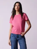 Buzo tejido en hilado fino color rosado, de corte recto y manga corta.