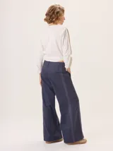 Pantalón de pierna ancha color azul marino con pespuntes a contratono (rojo/bordó) y una tira contrastante en el lateral.