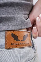 Jean de mezclilla celeste claro, corte wide leg y tiro alto, con pequeños apliques brillantes distribuidos por toda la prenda. El bajo está doblado.