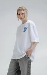 Remera blanca de corte holgado con estampado azul de diseño geométrico y aves.