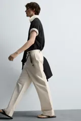 Pantalón negro de corte recto, con bolsillos frontales tipo parche y bolsillos traseros de ojal.