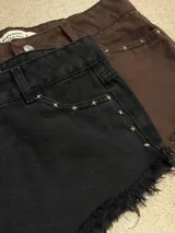 Shorts marrones con tachas, tiro alto y terminación desflecada.