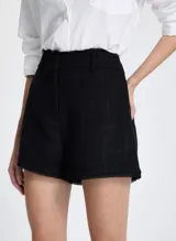 Short negro de tejido texturizado con corte recto, cinturilla con trabillas, cierre frontal con solapas, bolsillos traseros y bajo con ribete.