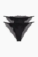 Pack de dos tangas negras de microfibra brillante y encaje, con tiras laterales finas, talle bajo y parte trasera semicubriente.