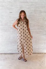 Camisola midi color beige con estampado de lunares negros, cuello camisero, sin mangas y abotonada al frente.