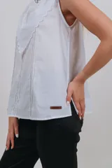 Musculosa blanca sin mangas con cuello babero de encaje.