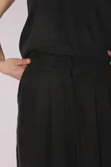 Conjunto de pantalón y top de seda color gris, con cuello halter y corte holgado.