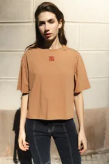Remera negra de algodón con corte cuadrado, cuello redondo y logo bordado en color naranja.