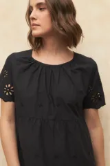 Vestido corto blanco con bordado calado y corte evasé.