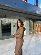 Pantalón marrón de cuero sintético con bolsillos laterales y corte recto.