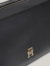 Bandolera Tommy Hilfiger negra con correa ajustable y logo metálico dorado en el frente.