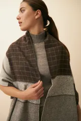 Chal unisex de lana fina sin teñir, realizado con retazos de telas diseñadas por Don Baez. Presenta una grifa de cuero aplicada.