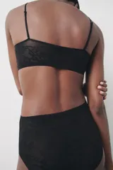 Braguita negra de tiro alto con cintura elástica y detalle de encaje floral en la parte trasera.