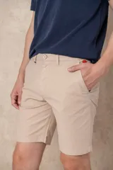 Bermuda color beige de corte clásico con bolsillos laterales y traseros.