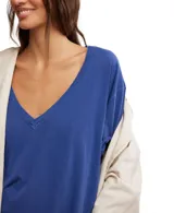 Remera negra de algodón, con escote en V profundo, mangas cortas y hombros caídos.