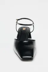 Zapato destalonado acharolado negro, con punta cuadrada, tacón ancho y pulsera al tobillo con hebilla.