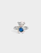 Anillo plateado con forma de oso y piedra azul.