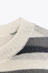Top de punto celeste con rayas horizontales en azul. Tiene cuello redondo y mangas cortas.