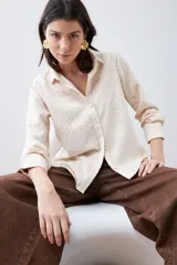 Camisa beige de manga larga con textura fantasía.