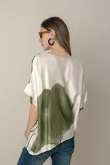 Blusa italiana color natural con estampado de hojas grandes en tonos marrones. Tiene cuello redondo y mangas cortas amplias.