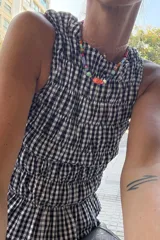 Top corto con estampado vichy en rojo y blanco, con breteles finos y detalle de fruncido en el escote.