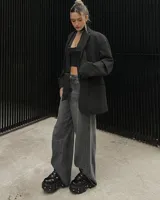 Borcego negro de cuero con plataforma track y detalles metálicos. Ajuste con cordones y hebillas.
