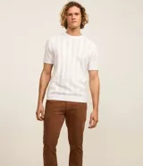 Pantalón de vestir color marrón, de corte recto, con bolsillos laterales y traseros. Se ajusta a la cintura con cinturón de cuero marrón.