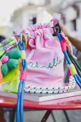 Cartera tipo tote bag color rosa claro, con cordones de colores y bordado verde con la palabra "Vanilla".