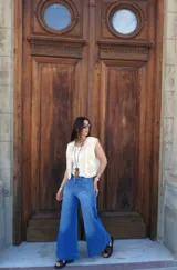 Pantalón de jean azul de corte pata elefante, tiro medio y confeccionado en denim con lycra.