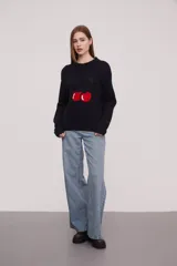 Sweater negro con estampado de cerezas en el frente, de corte holgado y manga larga.