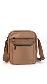 Morral bandolera color marrón de tela impermeable con dos bolsillos frontales con cierre y dos bolsillos internos. Incluye correa ajustable.