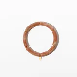 Pulsera rígida de color rosa con vetas blancas, compuesta por segmentos tubulares unidos por anillos dorados. Incluye un dije dorado en forma de gota.