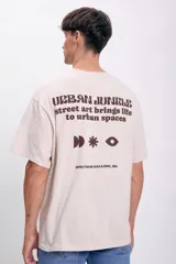 Remera beige de corte oversize con estampa en la espalda que dice 'Urban Jungle, street art brings life to urban spaces' y el nombre de la galería 'Spectrum Gallery, MN'.