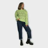 Sweater verde claro tejido en hilo calado con diseño geométrico.