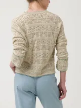 Sweater color crema de punto calado, con cuello redondo y mangas largas. Presenta detalles de crochet en cuello, puños y ruedo.