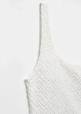 Traje de baño enterizo blanco con textura, forro interior, hombro descubierto, diseño asimétrico y tirante ancho.