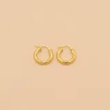 Aros tipo argolla en oro amarillo 18k con diseño texturizado.
