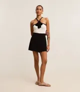 Short pollera negro confeccionado en crepé con traspase envolvente.