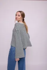 Remera de mangas largas a rayas horizontales verdes y blancas, de corte amplio y cuello redondo.