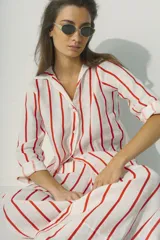 Camisa a rayas verticales blancas y negras, de corte recto y mangas largas.