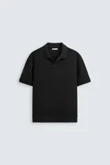 Polo de hombre de corte regular, color negro, con cuello solapa y abertura frontal, manga corta y bajo con acabado en rib.
